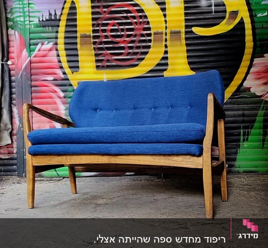 ספה כחולה עם ריפוד על רקע גרפיטי צבעוני